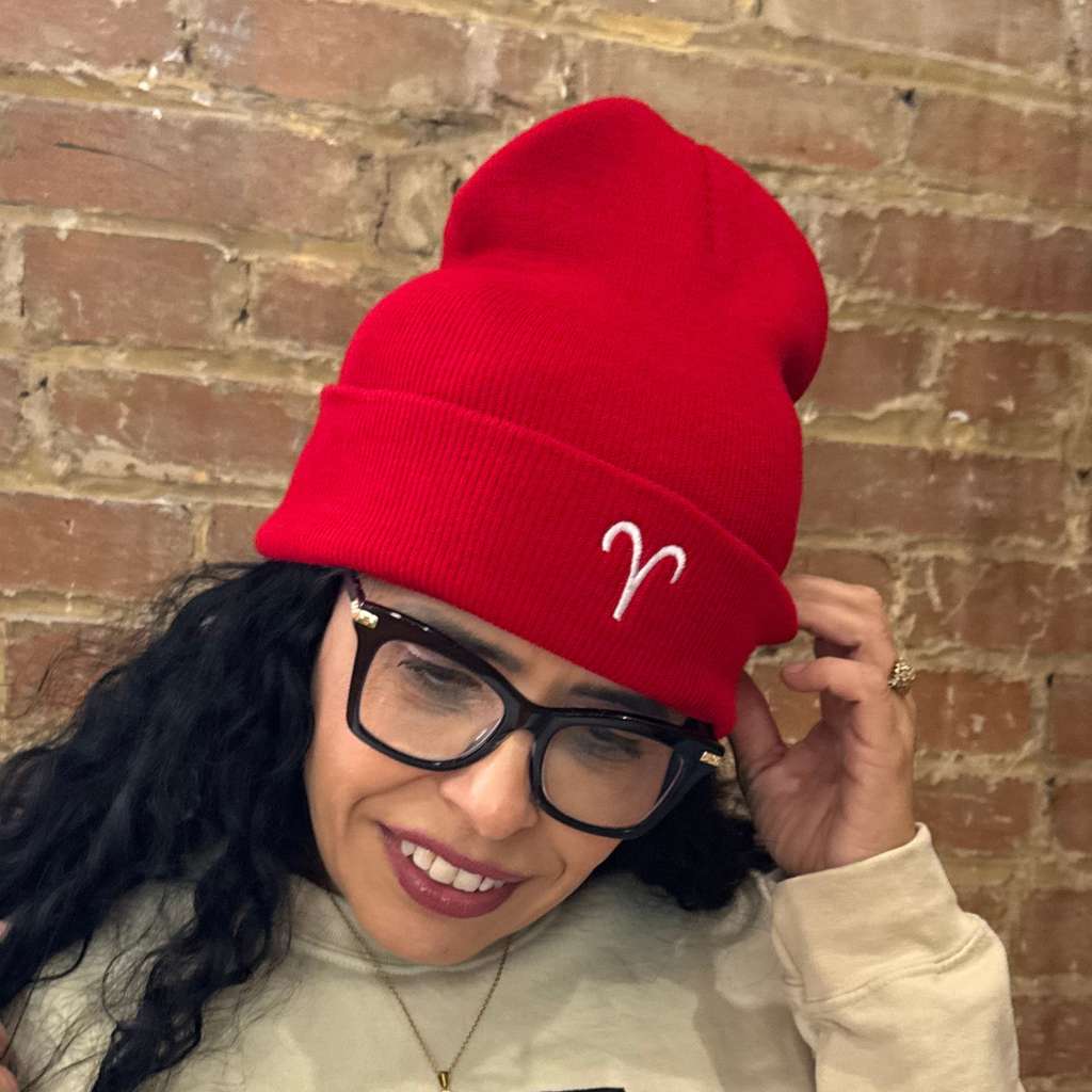 Latina woman wearing a red Aries embroidered beanie. Trendy zodiac streetwear outfit perfect for astrology lovers and everyday casual style – DSY Lifestyle.