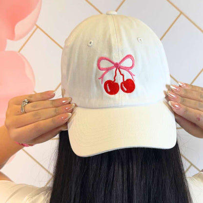 Women wearing a White baseball hat embroidered with a cherry and bow - DSY Lifestyle