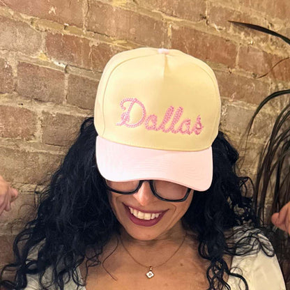 Female wearing a 5 panel hat that has Dallas embroidered in a chain stitch. The hats is Natural Crown with Pink bill for Spring Fashion - DSY Lifestyle