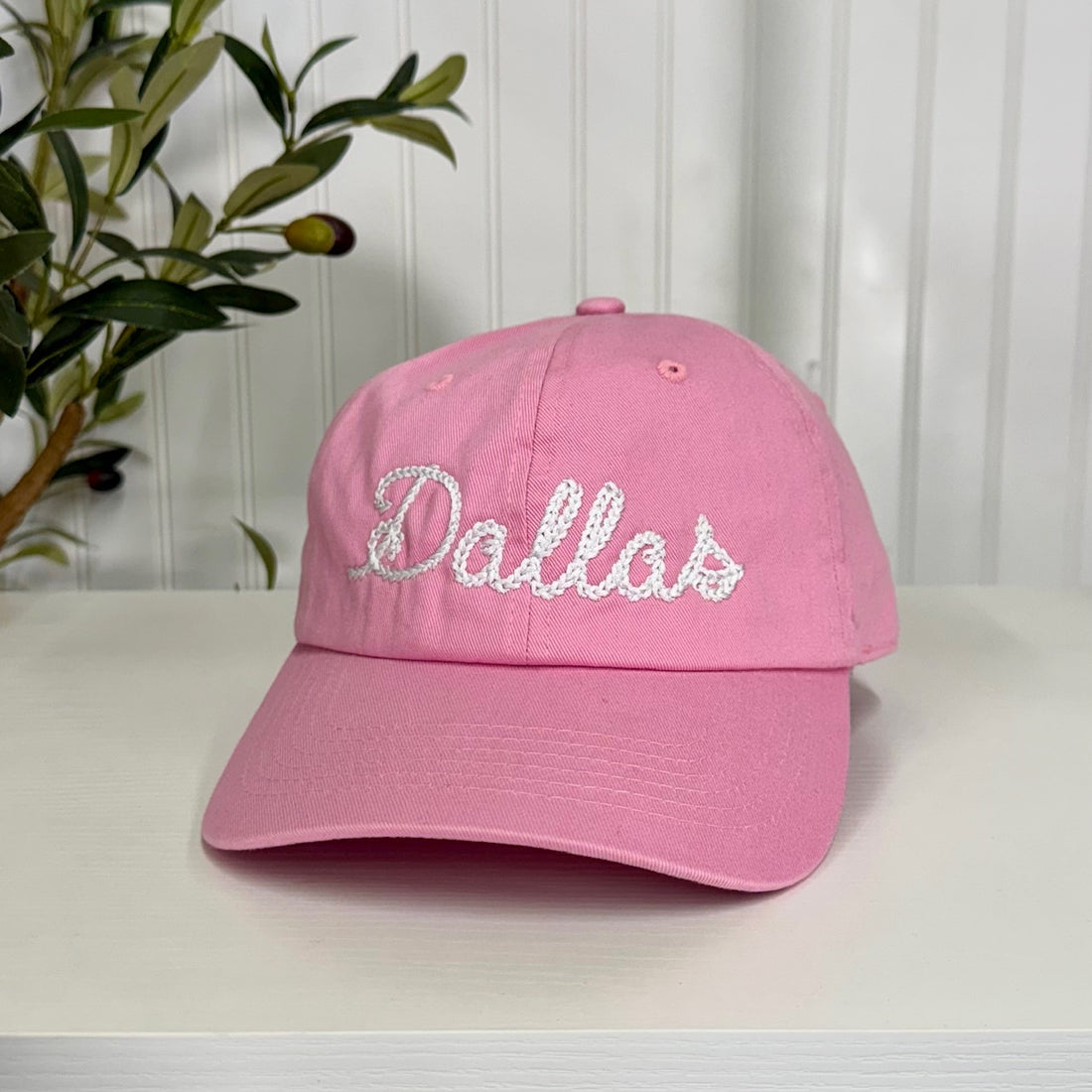 Light Pink baseball hat with &quot;Dallas&quot; embroidered in chain stitch cursive, offering a classic and stylish way to rep your city - DSY Lifestyle