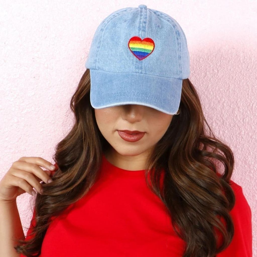 Model wearing light denim baseball hat embroidered with pride flag in heart shape-DSY Lifestyle