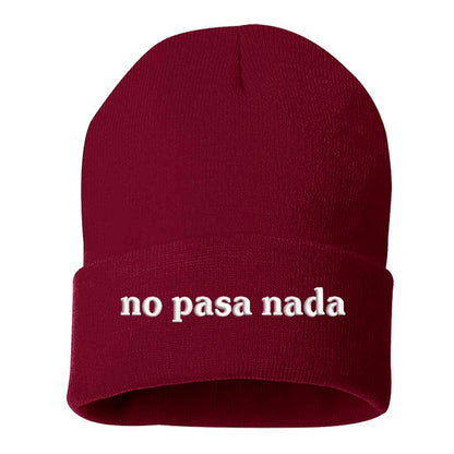 Flat lay of No Pasa Nada Spanglish Burgundy beanie, a cozy winter hat with chill vibes