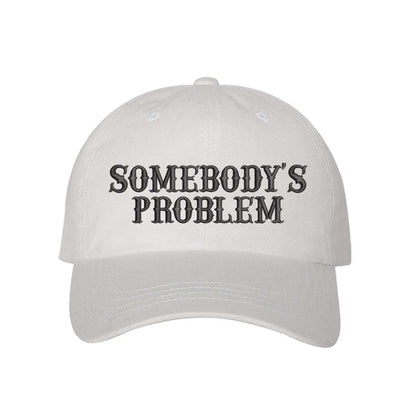 White baseball hat embroidered with the phrase somebody&