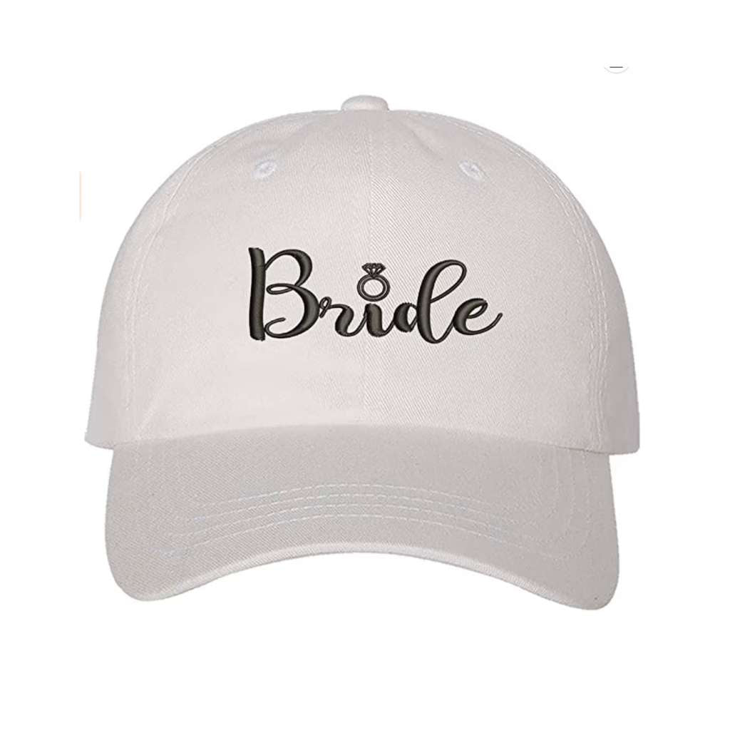 White embroidered baseball hat featuring the word Bride with a delicate engagement ring design, perfect for bridal celebrations and honeymoon outfits - DSY Lifestyle