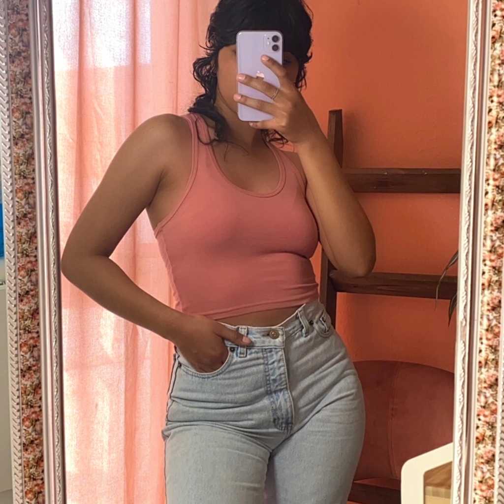 female in front of a mirror tanking a selfie with a mauve Racerback crop tank top and denim jeans-DSY Lifestyle